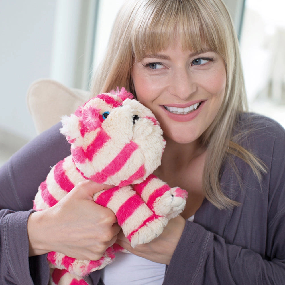 Smiling woman cuddling Warmies Bagpuss Cat microwavable toy.