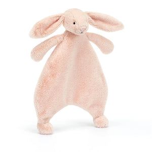 Jellycat Bashful Blush Bunny Comforter in soft blush pink plush, tilted playfully with floppy ear and hand outstretched for cuddling.