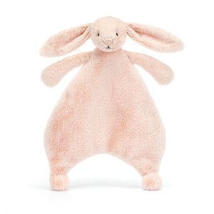 Super-soft Jellycat Bashful Blush Bunny Comforter. Adorable bunny with floppy ears and blushed cheeks in calming pink blush recycled plush fur.