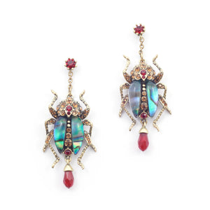 Front view of Bill Skinner bejewelled beetle earrings with antique gold finish and red crystal drop.