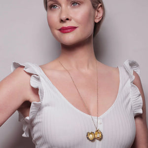 Model wearing open Bill Skinner Blackberry & Mouse Locket Necklace on long gold chain, featuring enamelled mouse hidden inside blackberry pendant