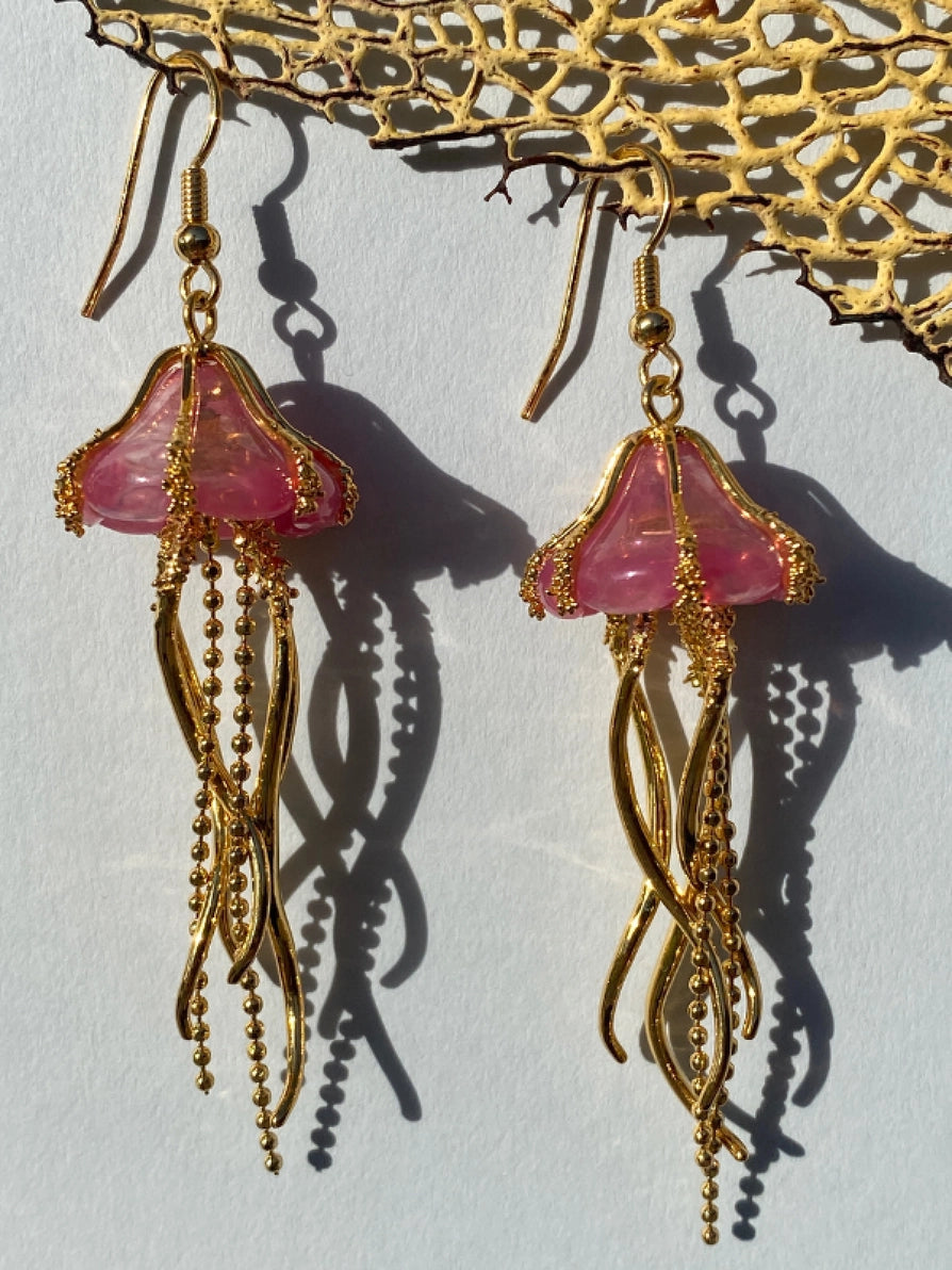 Close-up of Jellyfish Drop Earrings hanging in sunlight, showcasing intricate tentacle details.