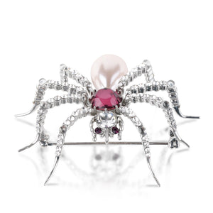 Side profile of Pearl Spider Brooch by Bill Skinner showing dimensional silver legs set with sparkling crystals, a faceted amethyst gemstone, and a large pearl drop accent.