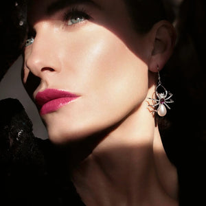 Model wearing Bill Skinner Pearl Spider Drop Earrings, showcasing the statement spider design with amethyst and pearl detailing, styled in dramatic lighting for a bold, elegant look.