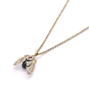 Side angle of moth pendant showing antique finish and crystal detail.