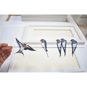 Acrylic Glass Artwork of Swallows – A transparent acrylic glass panel featuring a printed design of swallows sitting on a wire, with one swallow flying towards them. The artwork is being held up to display the design.