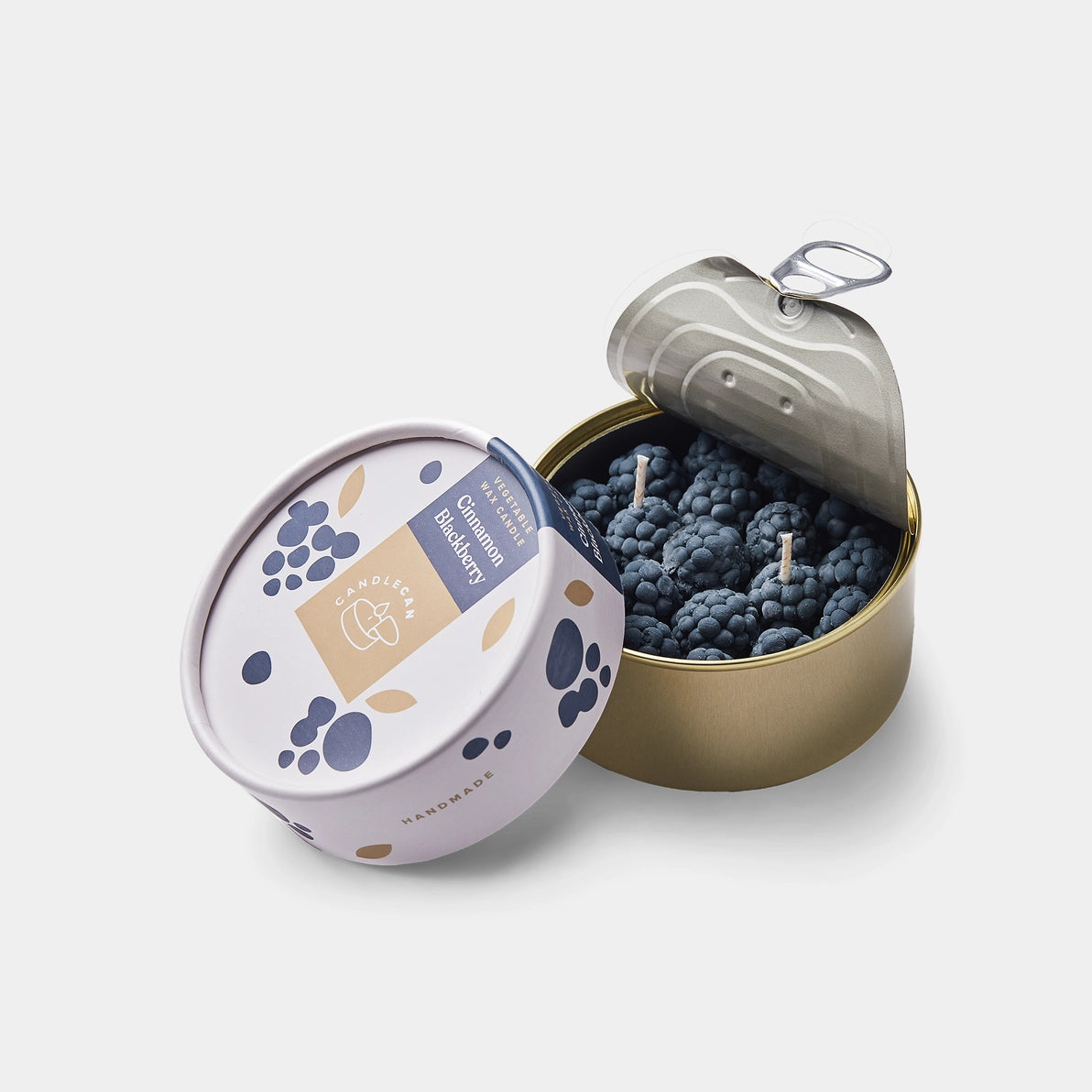 Open tin of Cinnamon Blackberry Candle showing lifelike blackberry wax detail and premium sealed packaging.