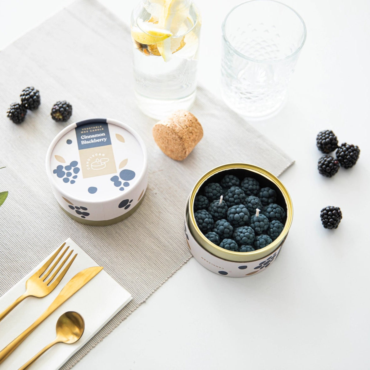 Blackberry Cinnamon Candle styled on dining table with fruit, gold cutlery, and lemon water—perfect foodie gift setup.