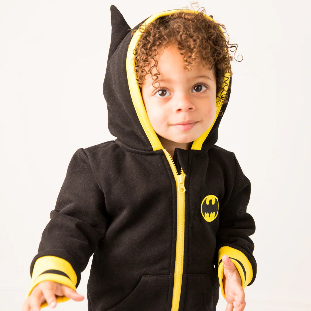 Toddler wearing Batman “Get Ready” Hoodie with pointed bat ears on hood, bright yellow zip, cuffs, and hem, plus iconic yellow bat logo on chest.