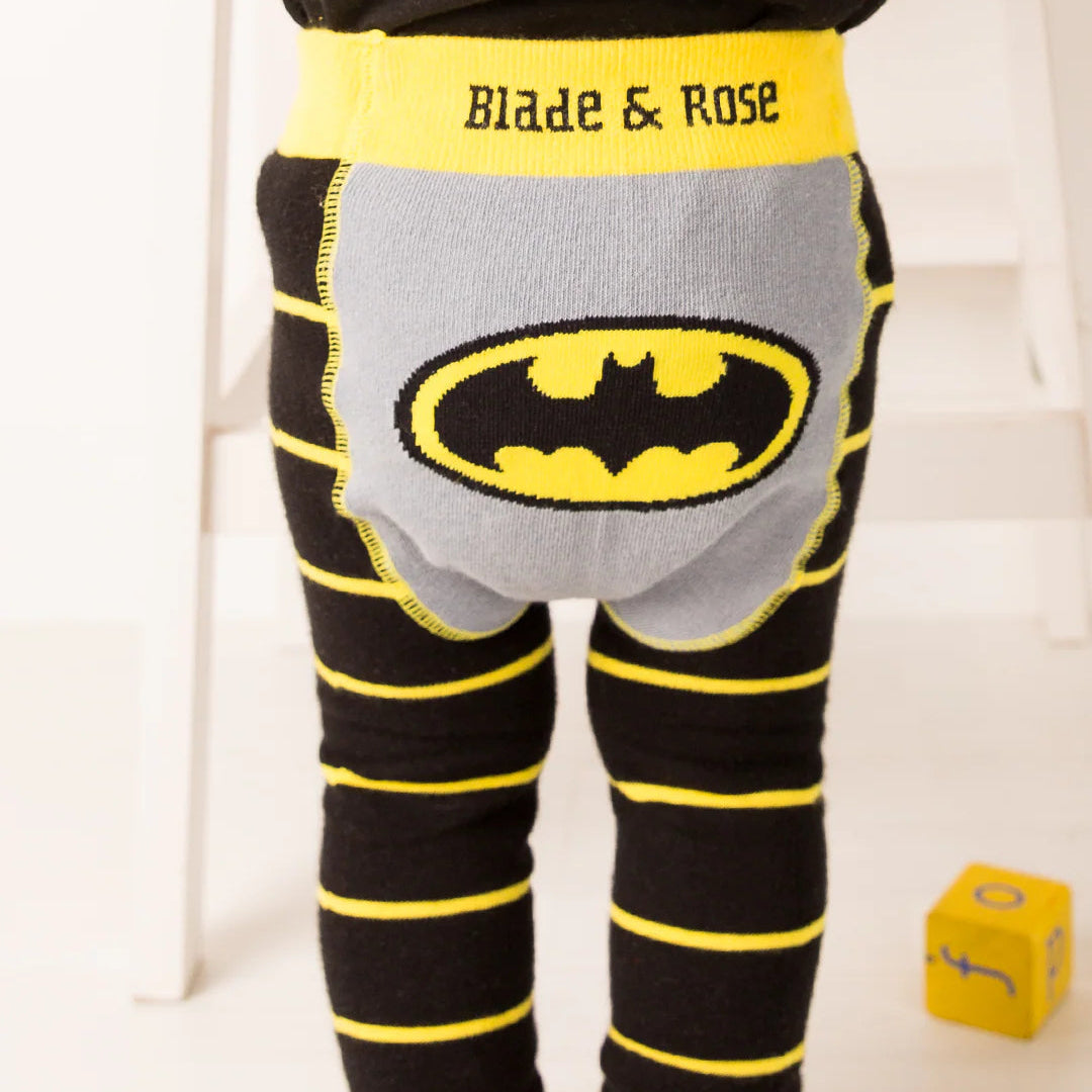 Baby standing in Blade & Rose Batman™ “Get Ready” leggings, showing bold black and yellow stripes and Bat-signal design on the seat.
