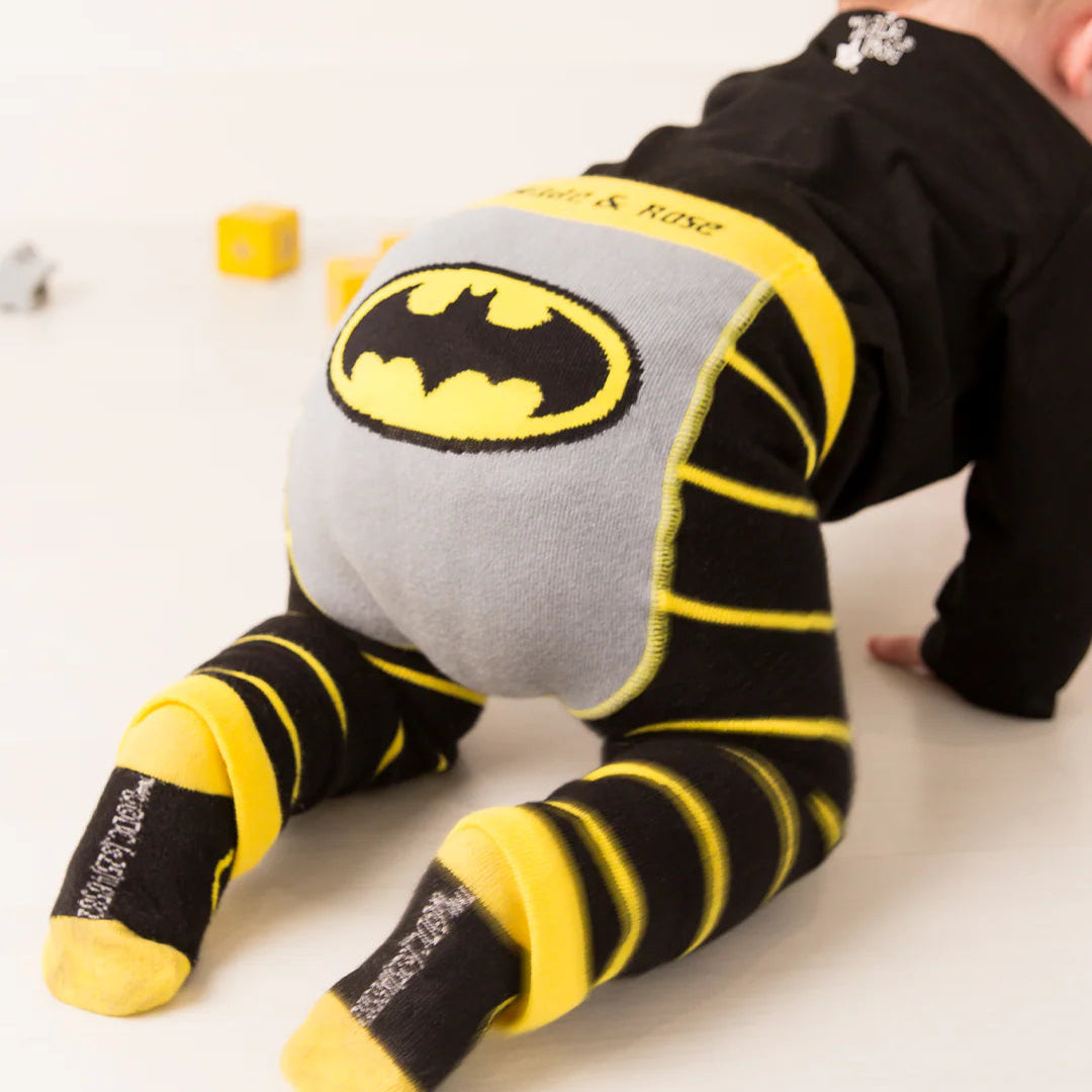 Baby crawling in Blade & Rose Batman™ leggings with bright yellow and black striped legs and large Bat-signal logo on grey seat panel.