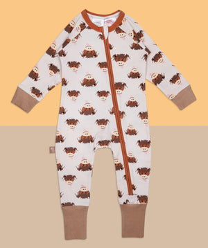 Flat lay of the Neutral Hamish Highland Cow zip-up romper against a warm-toned background, highlighting the zip and printed design.