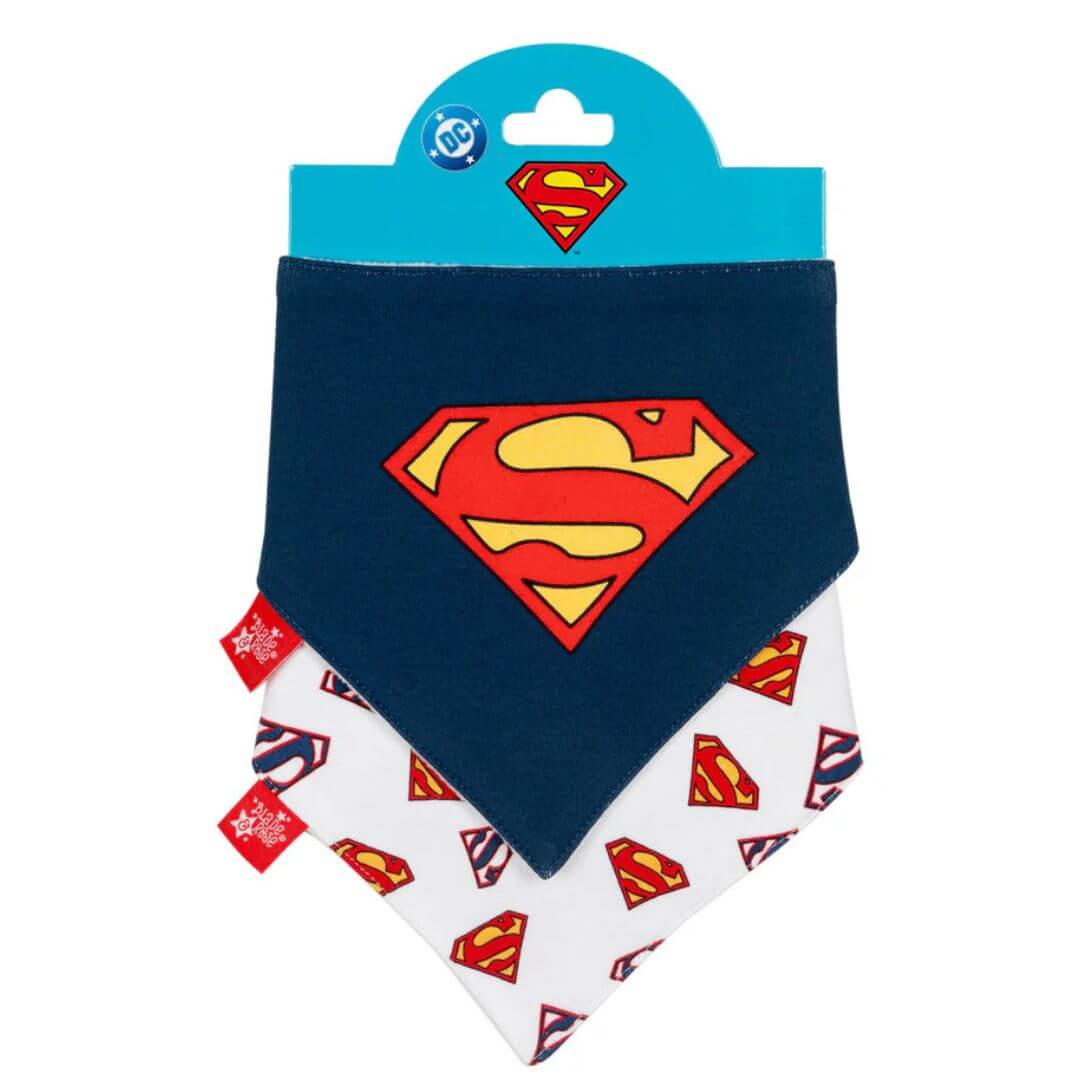 Two-pack Superman™ baby bib set in packaging, one navy bib with large red and yellow “S” shield logo layered over a white bib with all-over Superman™ logo print.