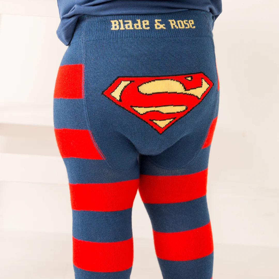 Baby wearing Blade & Rose Superman™ Saves the Day leggings, featuring bold navy and red stripes with large yellow and red Superman™ shield on the bum.
