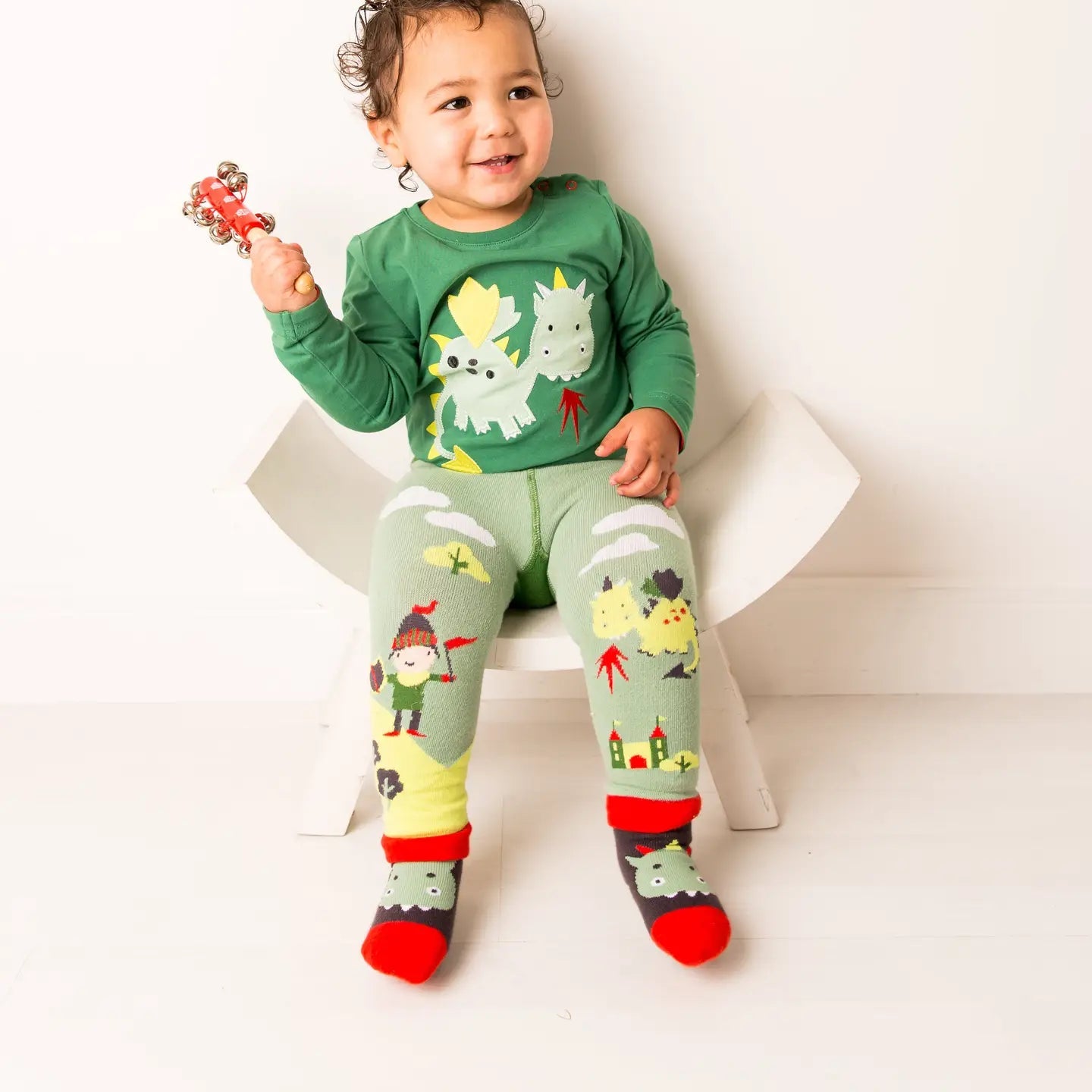 Child wearing full Teddy the Dragon outfit with matching top, leggings, and socks.
