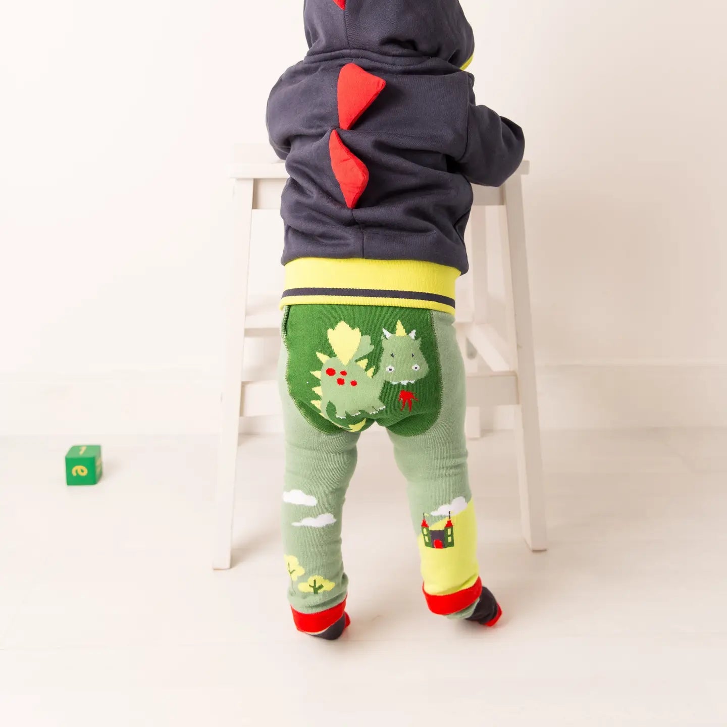 Toddler in Blade & Rose dragon hoodie and matching dragon leggings, seen from behind.