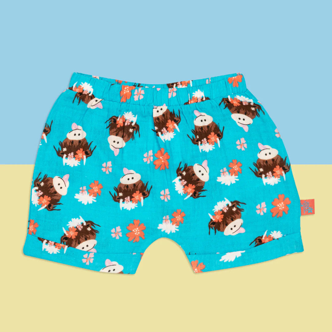 Front view of Bonnie Highland Cow baby shorts in blue muslin with floral cow print.