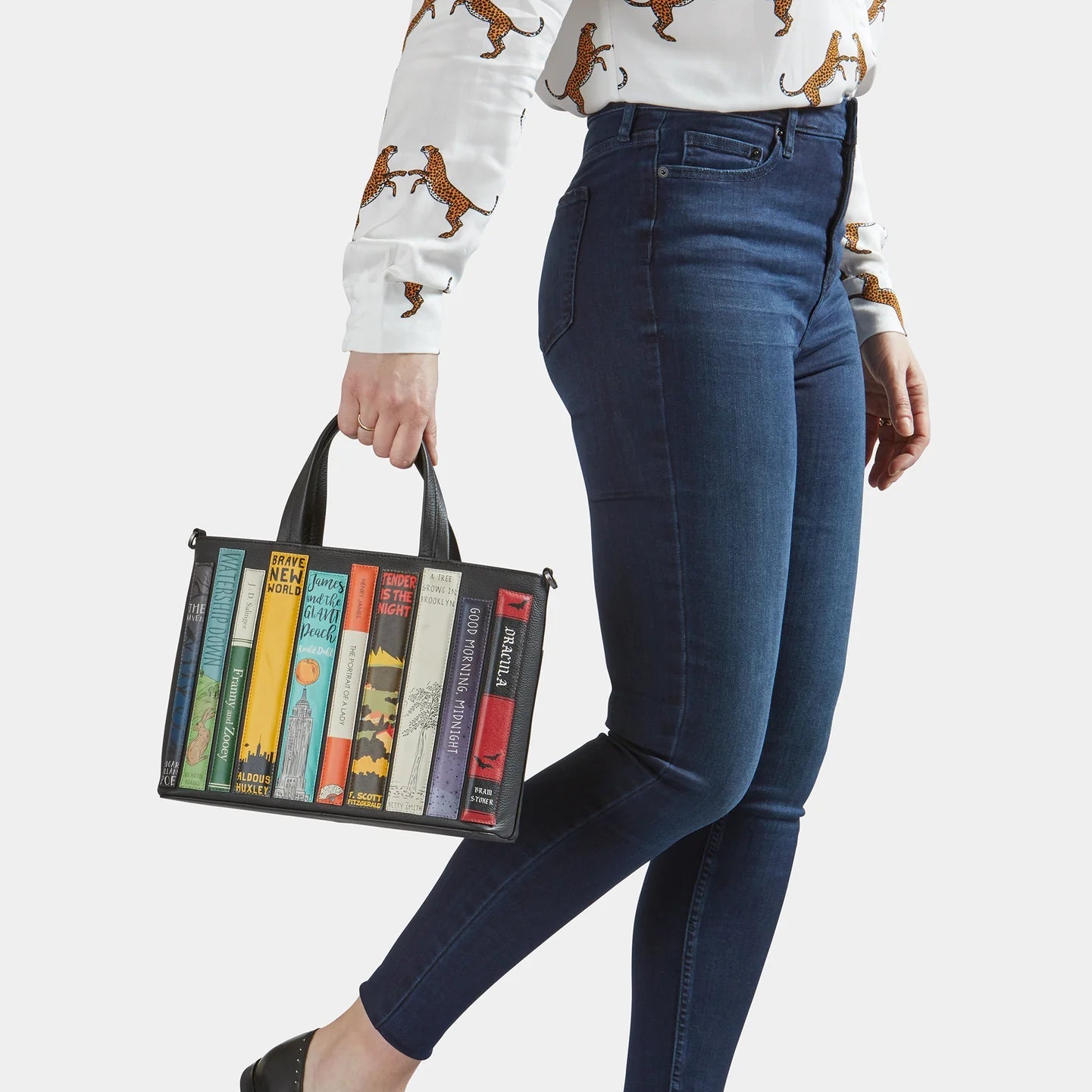 Model holding Bookworm Black Leather Multiway Grab Bag by top handles.