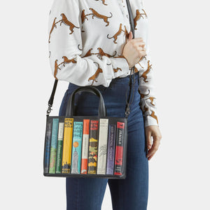 Model wearing Bookworm Black Leather Multiway Grab Bag crossbody with detachable strap.