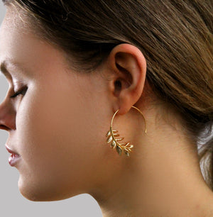 Side view of gold botanical leaf hoop earrings being worn, illustrating their 3.5 cm hoop size.