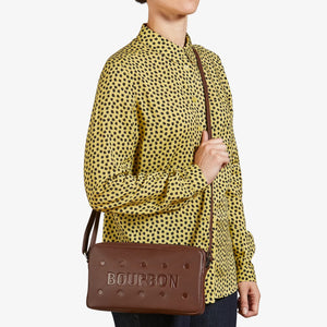 Model wearing Bourbon Biscuit Leather Cross Body Bag across the body with adjustable strap.