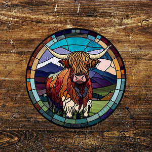 Highland Cow Stained Glass Effect Circle Metal Sign featuring a vibrant, artistic depiction of a Highland cow against a scenic mountain backdrop. Durable aluminium design, suitable for indoor and outdoor display. 11 inches x 11 inches.