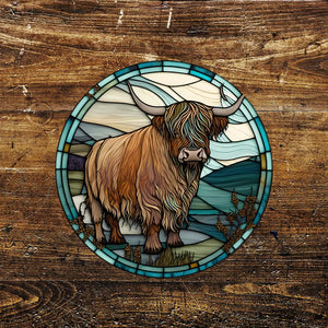 A round metal sign featuring a Highland cow standing against a scenic landscape, designed with a stained glass effect. The sign has a rustic, vintage-inspired look and is set against a wooden background.