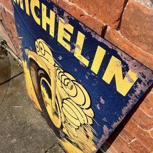 Angled view of the Michelin metal sign against a brick wall, highlighting the weathered effect and bold typography of the vintage-style design.