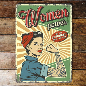 Retro Women Power Metal Wall Sign featuring a vintage-inspired illustration of a strong woman with a red bandana and tattoos, flexing her arm with the words “Women Power” and “You Are Stronger Than You Think.” The sign has a distressed design for a classic retro look.