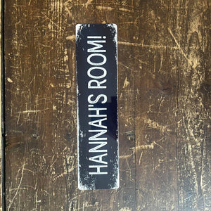 A long, slim custom metal sign with “HANNAH’S ROOM!” text, showcasing a vintage-style design, perfect for personalised home or office décor.
