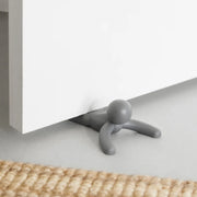 Umbra Buddy doorstop in charcoal holding open a wooden door