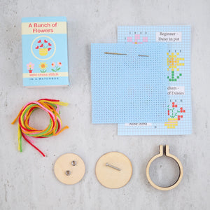 Complete contents of the mini cross stitch kit, including fabric, thread, and hoop.