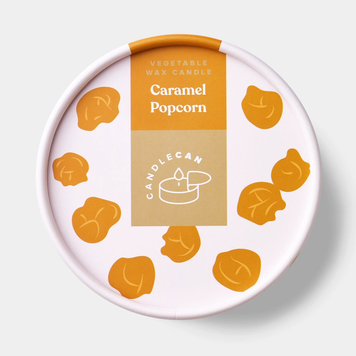 Close-up of Caramel Popcorn candle tin lid with playful popcorn illustrations and branded Candlecan label on white and caramel background.