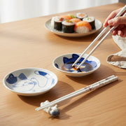 Cat chopsticks and dipping bowls set in use with sushi on wooden table