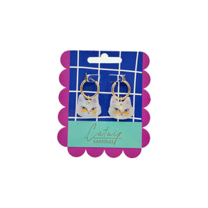 Catnip Cat Hoop Earrings in packaging – A pair of gold hoop earrings with iridescent acrylic cat charms, displayed on a colourful backing card with a grid and scalloped edges.