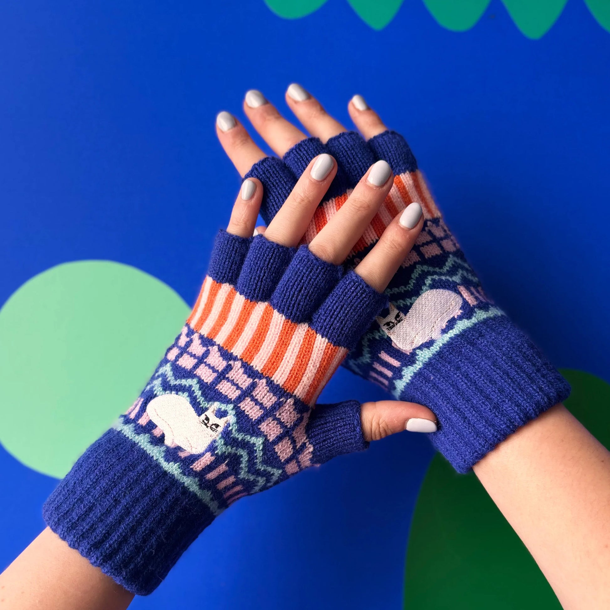 Catnip Fair Isle knit fingerless gloves worn on hands, showing colourful striped and patterned design with embroidered cat, stylish winter accessories for cat lovers.