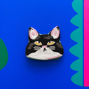 Front view of Catnip Cat Coin Purse with beaded black-and-white cat face and golden eyes.