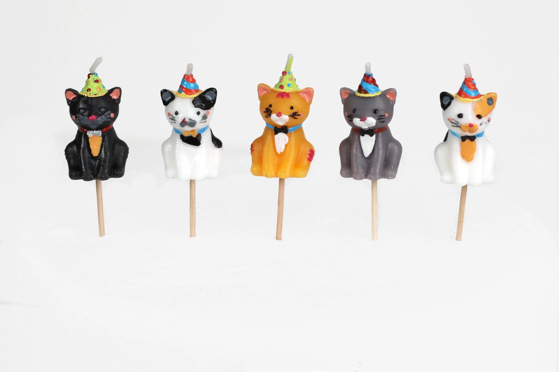 Set of five adorable 3D cat-shaped cake candles wearing colourful party hats, each with a wooden pick for easy placement.