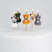 Lit Cats in Party Hats Cake Candles on a cake, showcasing a fun and playful design for a unique cake decoration.