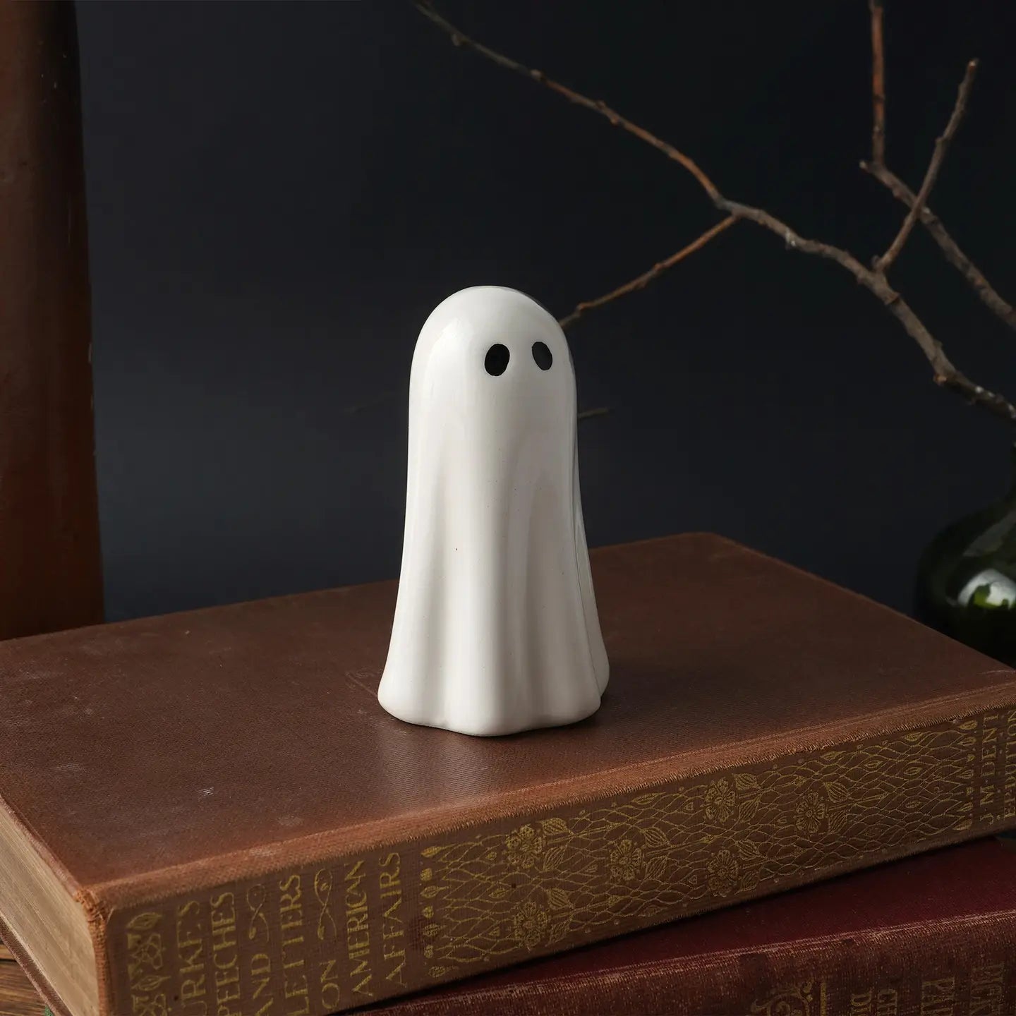 Front view: Glossy white ceramic ghost ornament with black eyes.