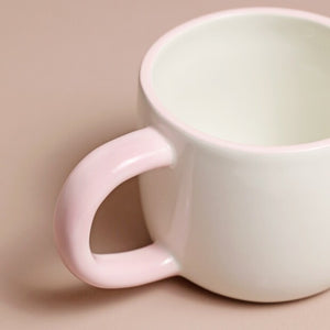 Close-up of the mug handle in soft pink glaze for a comfortable grip.