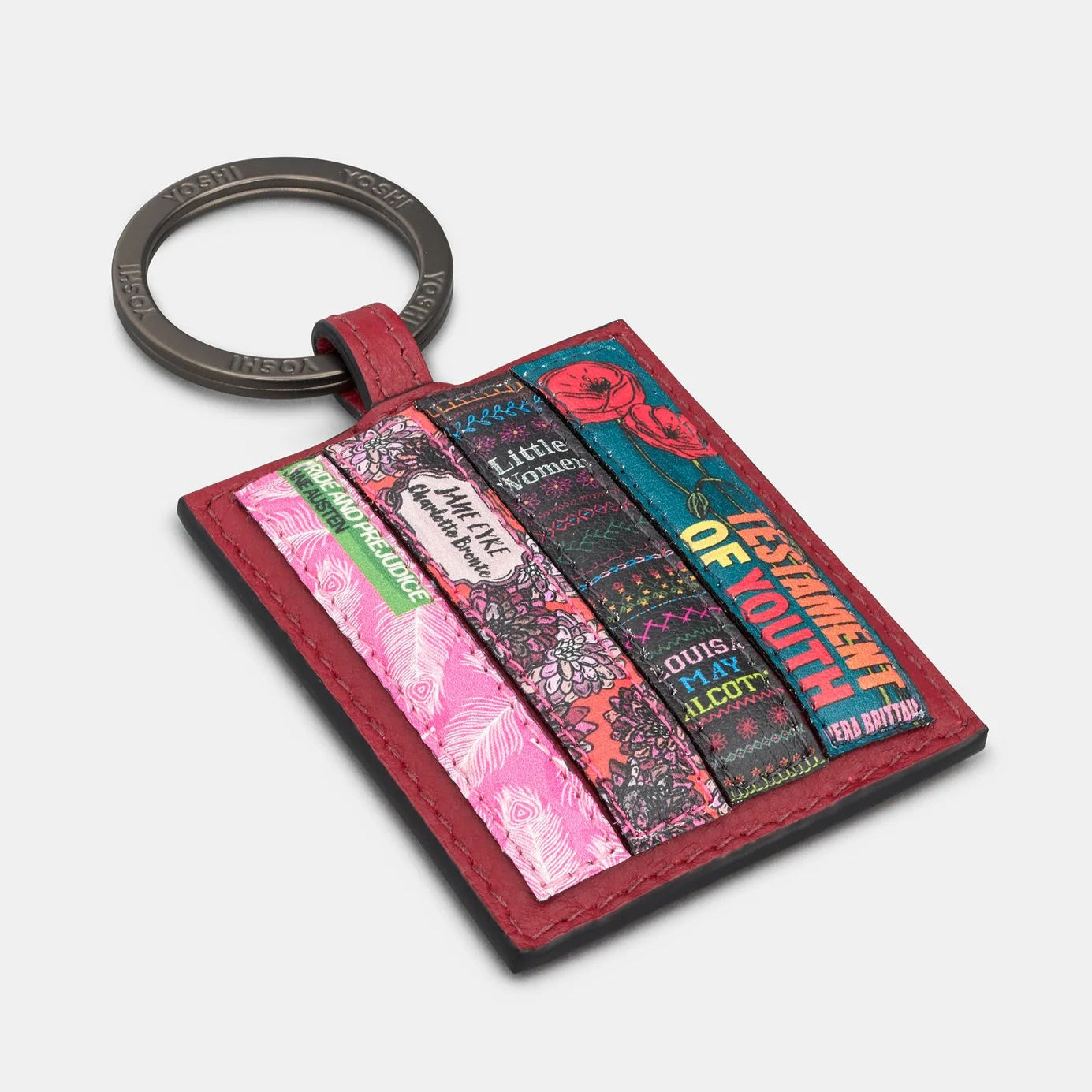 Angled close-up of cherry red leather bookworm keyring showing secure split ring and detailed spine embroidery.