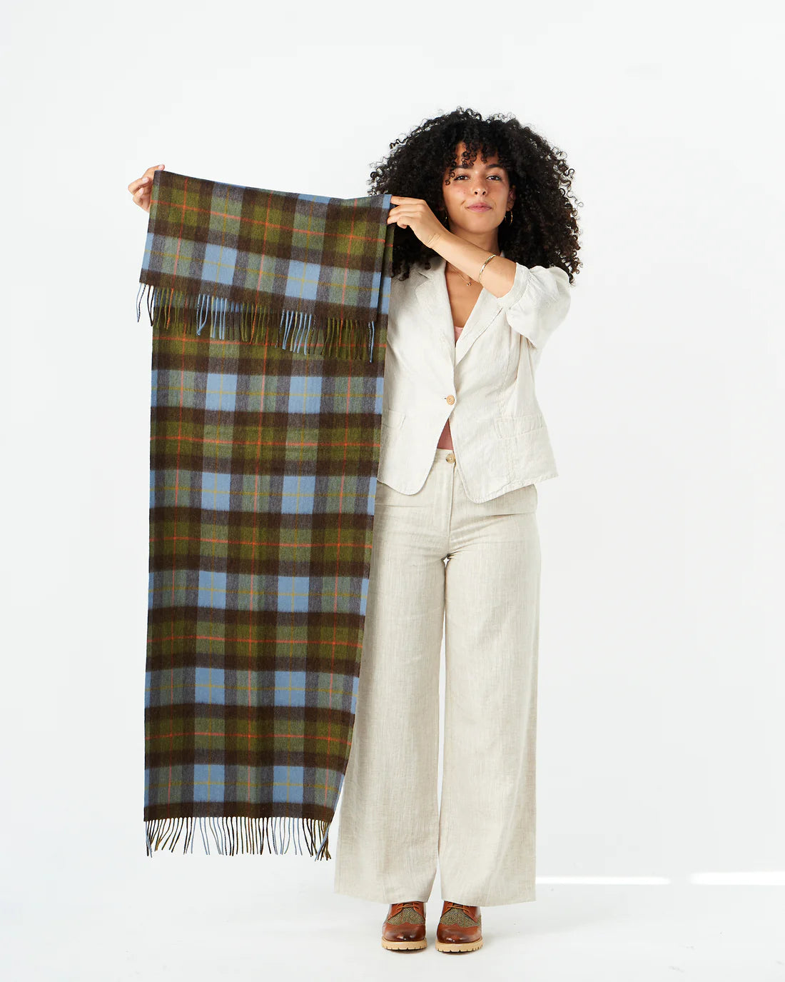 Model holding chestnut and blue tartan lambswool scarf to show size.
