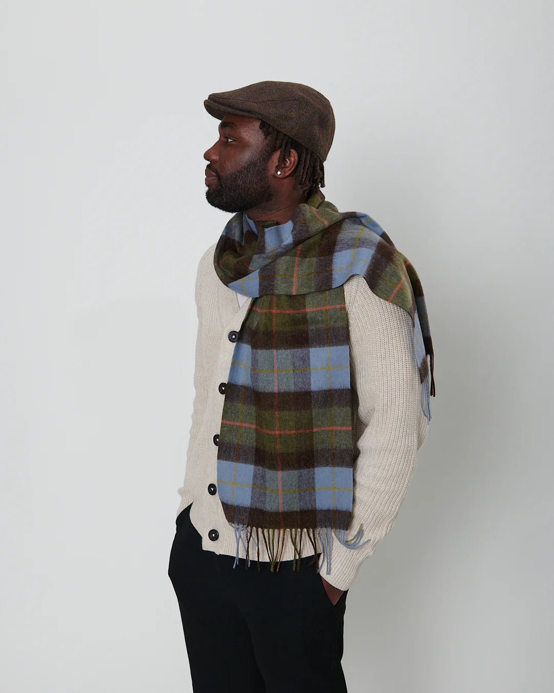 Man wearing chestnut and blue tartan lambswool scarf styled with coat.