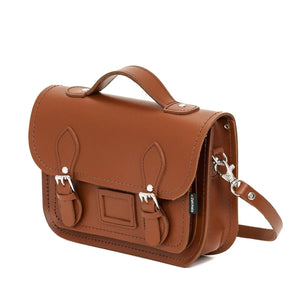 Side view of the chestnut brown leather satchel with shoulder strap.