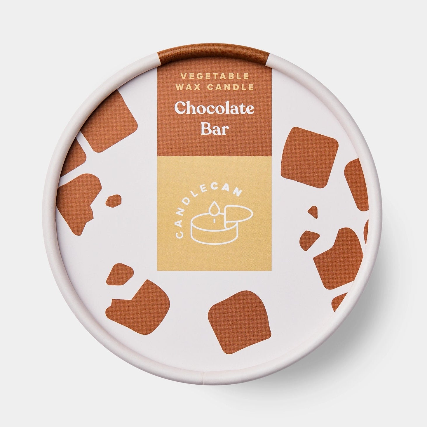 Close-up of round gift-style tin with chocolate-themed packaging for vegetable wax candle, labelled “Chocolate Bar”.