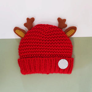 Red Christmas Reindeer Winter Hat with brown antlers and ears on flat background – festive toddler knit hat.