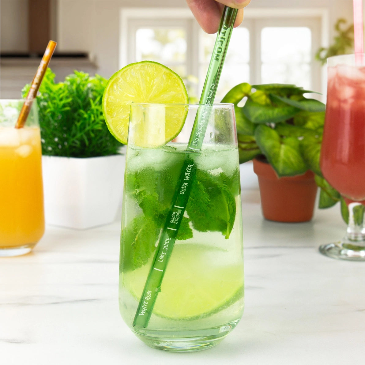 Green Mojito cocktail recipe straw in glass, showing ingredient lines for lime juice, mint, and soda water.