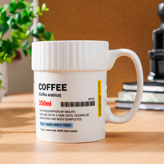 Coffee Pill Mug shaped like a prescription pill pot on a desk.