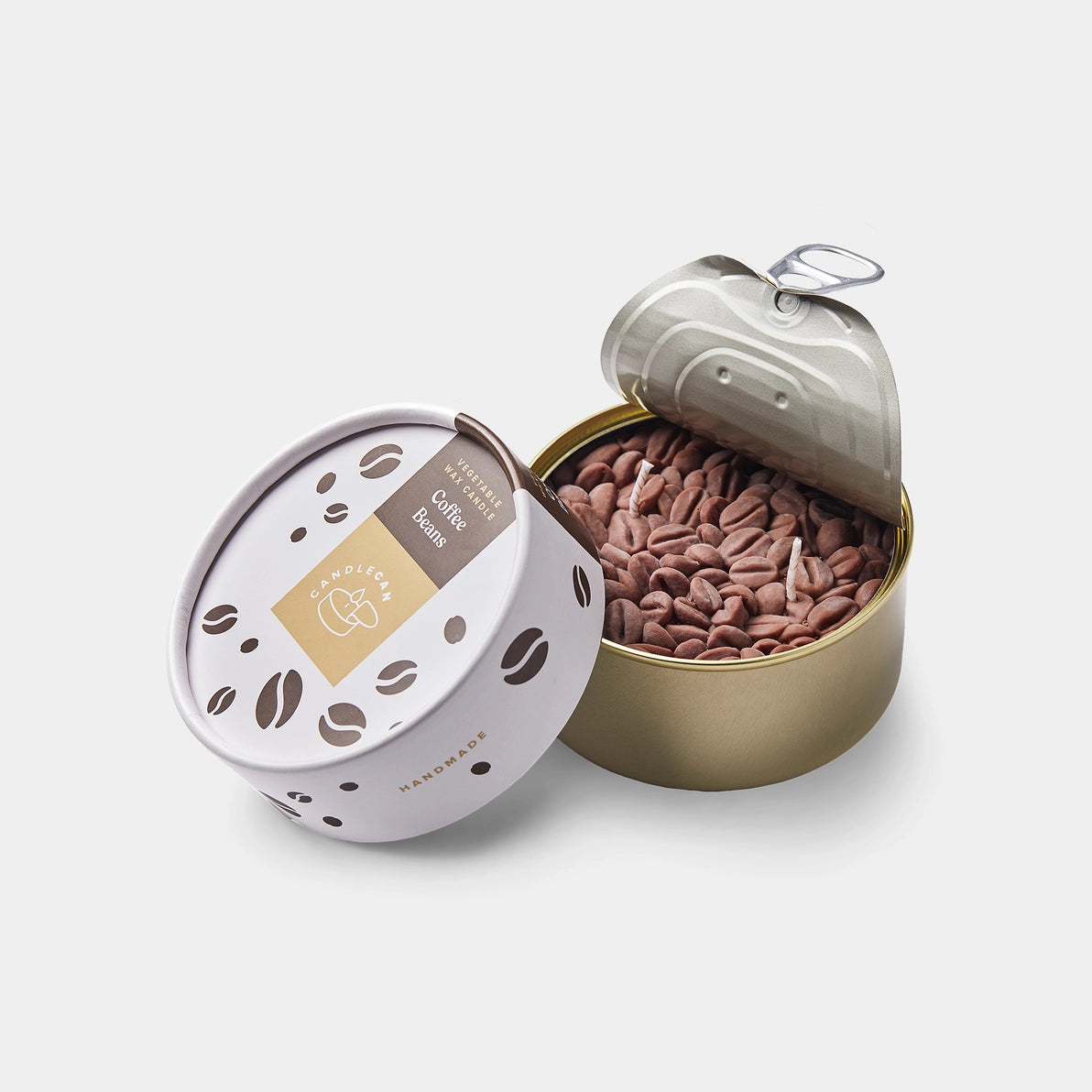 Opened Coffee CandleCan tin showing ultra-realistic wax coffee beans and twin wicks inside a golden can, with matching packaging beside it.